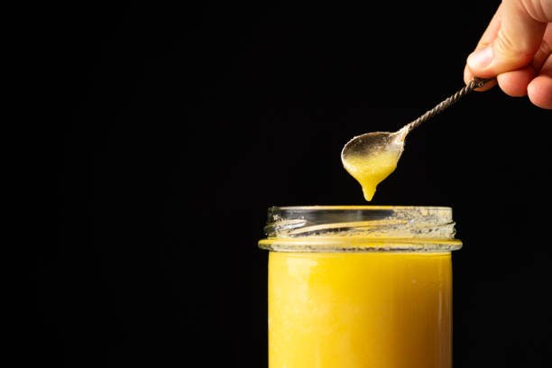 Natural ghee healthy lactose-free oil for frying, black background, copy space for text.