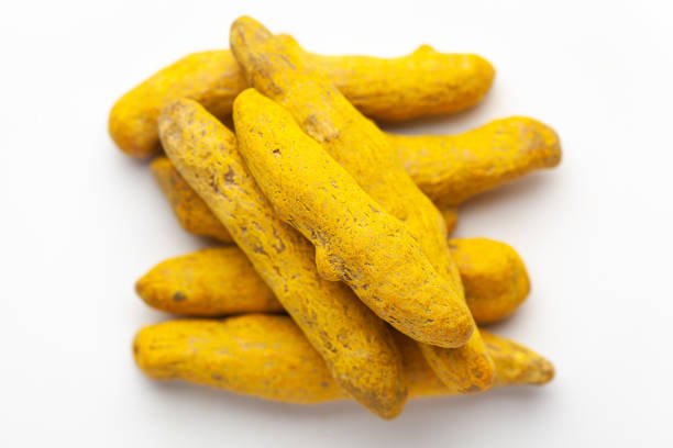 Macro close-up of Organic dry turmeric root (Curcuma longa) on white background. Pile of Indian Aromatic Spice. Top view